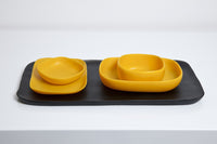 Yellow bowls, dishes, and black serving platter 